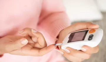 Close up of woman hands checking blood sugar level by Glucose me