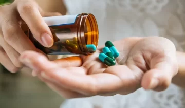woman-s-hand-pours-medicine-pills-out-bottle-960x641
